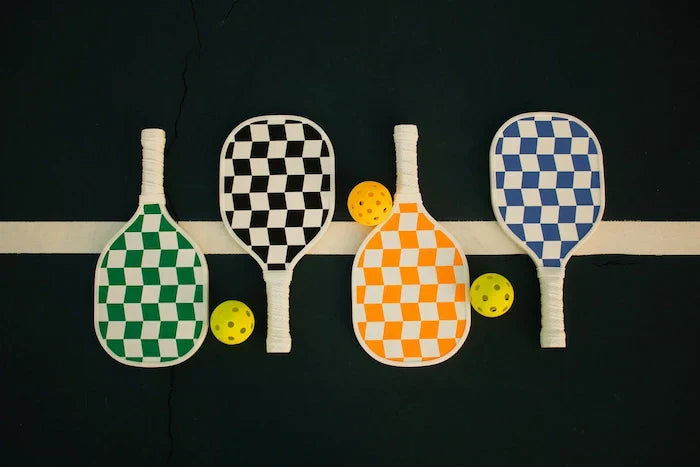 Raquettes de pickleball colorées avec balles jaunes sur fond noir