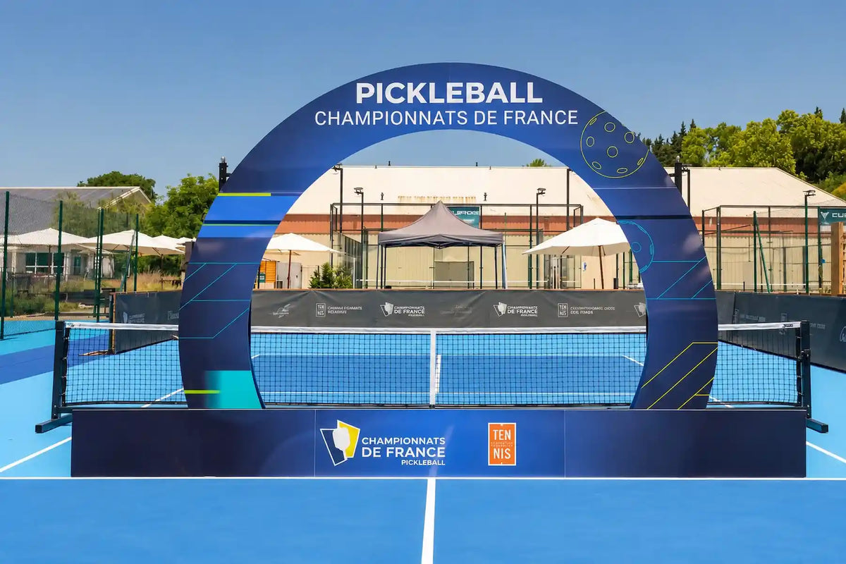 Terrain de pickleball avec une arche des championnats de France, organisés sous l'égide de la Fédération française de Tennis (FFT).