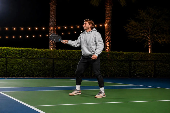 Joueur de pickleball représentant les niveaux 3.5 et 4.0 lors d’un échange sur un terrain extérieur