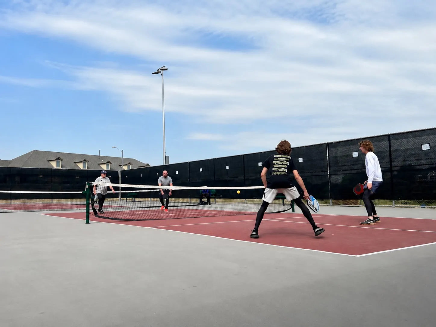 4 joueurs de pickleball sur un terrain entrain de faire une partie