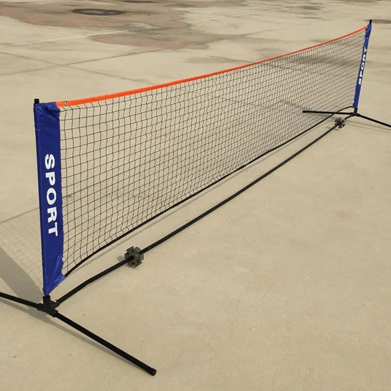 Vue d'angle d'un filet de pickleball portable installé sur sol dur, montrant la structure en acier noir et la tension du filet.