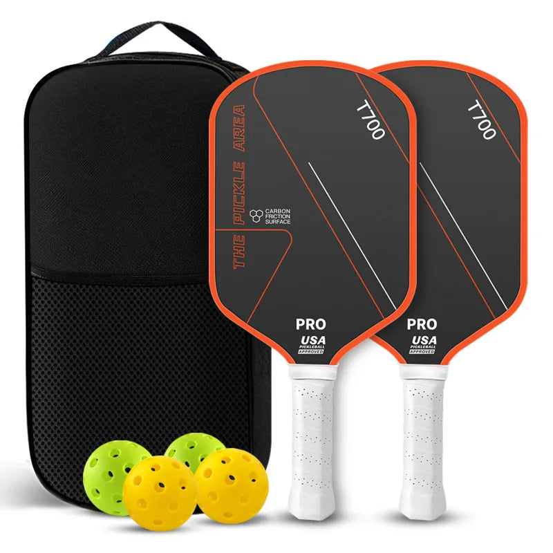 Pack de deux raquettes de pickleball The Pickle Area noires avec bordure orange, carbone T700, sac de transport, deux balles jaunes et deux balles vertes.
