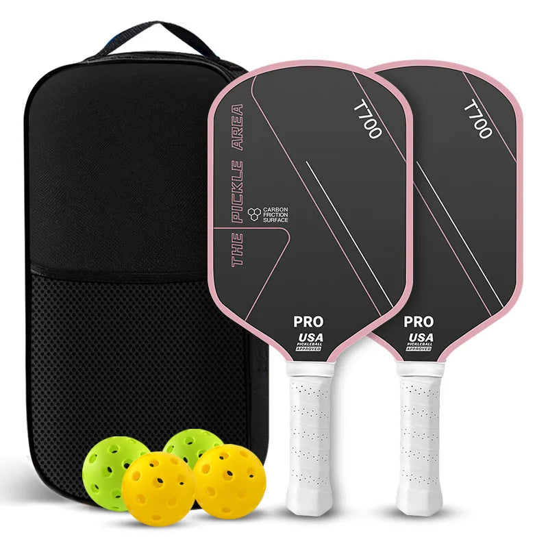 Pack de deux raquettes de pickleball The Pickle Area noires avec bordure et grip rose clair, carbone T700, sac de transport, deux balles jaunes et deux balles vertes.