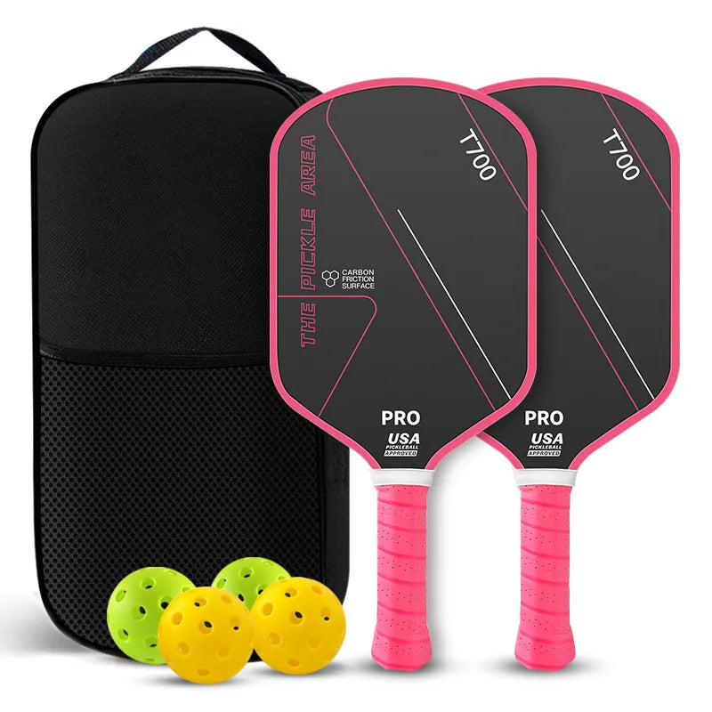 Pack de deux raquettes de pickleball The Pickle Area noires avec bordure et grip roses, carbone T700, sac de transport, deux balles jaunes et deux balles vertes.