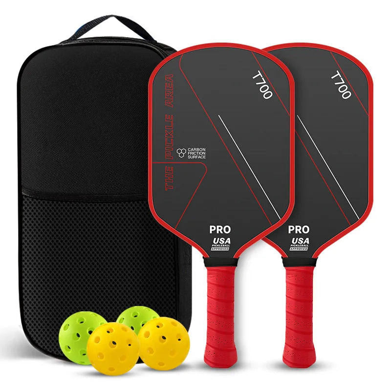 Pack de deux raquettes de pickleball The Pickle Area noires avec bordure et grip rouges, carbone T700, sac de transport, deux balles jaunes et deux balles vertes.